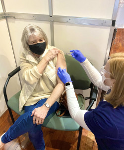 Kirker administering the COVID-19 vaccine to her mother at the TLA clinic.